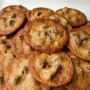 a stack of the Crispiest Chocolate Chip Cookies on a white plate