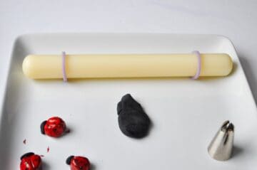 a mound of black fondant with a small fondant rolling pin