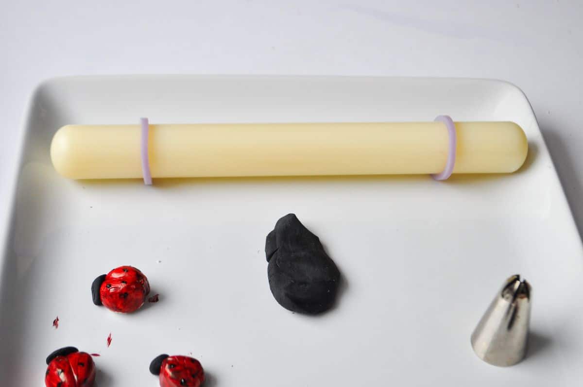 a mound of black fondant with a small fondant rolling pin