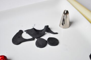 black fondant circles cut out with a large metal piping tip