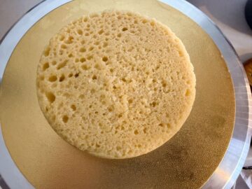 a vanilla cake layer on top of a gold cake board