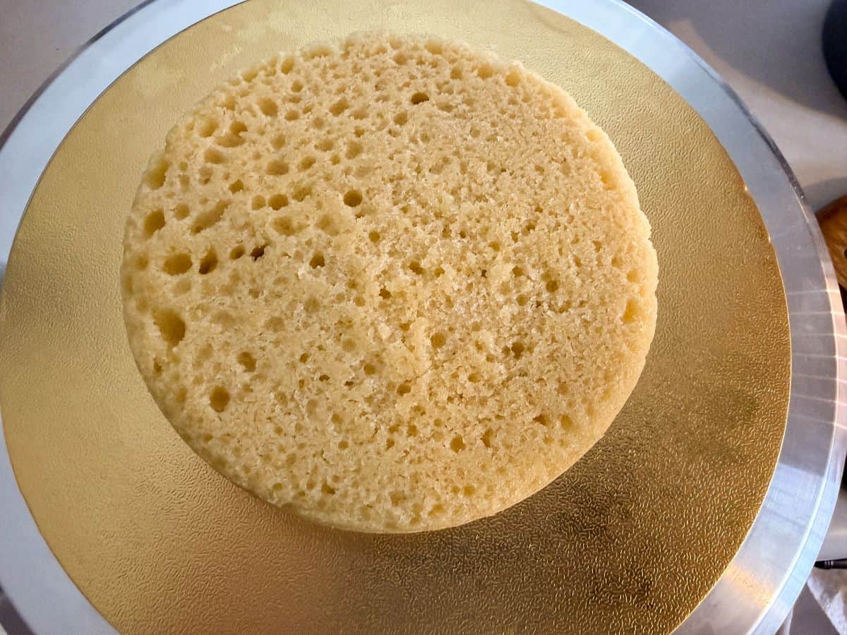 a vanilla cake layer on top of a gold cake board