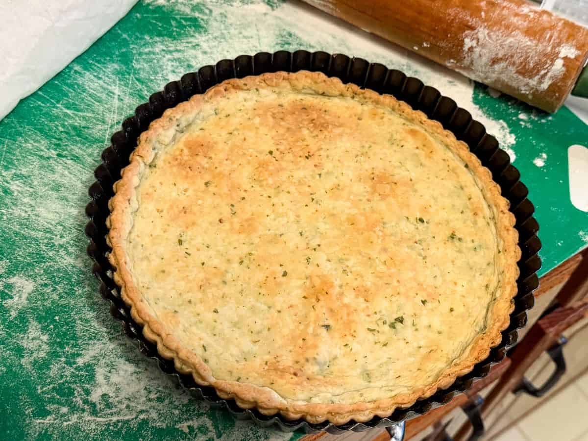 basil garlic tart crust in a tart pan that has been baked until golden