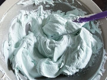 a bowl of light blue colored vanilla buttercream