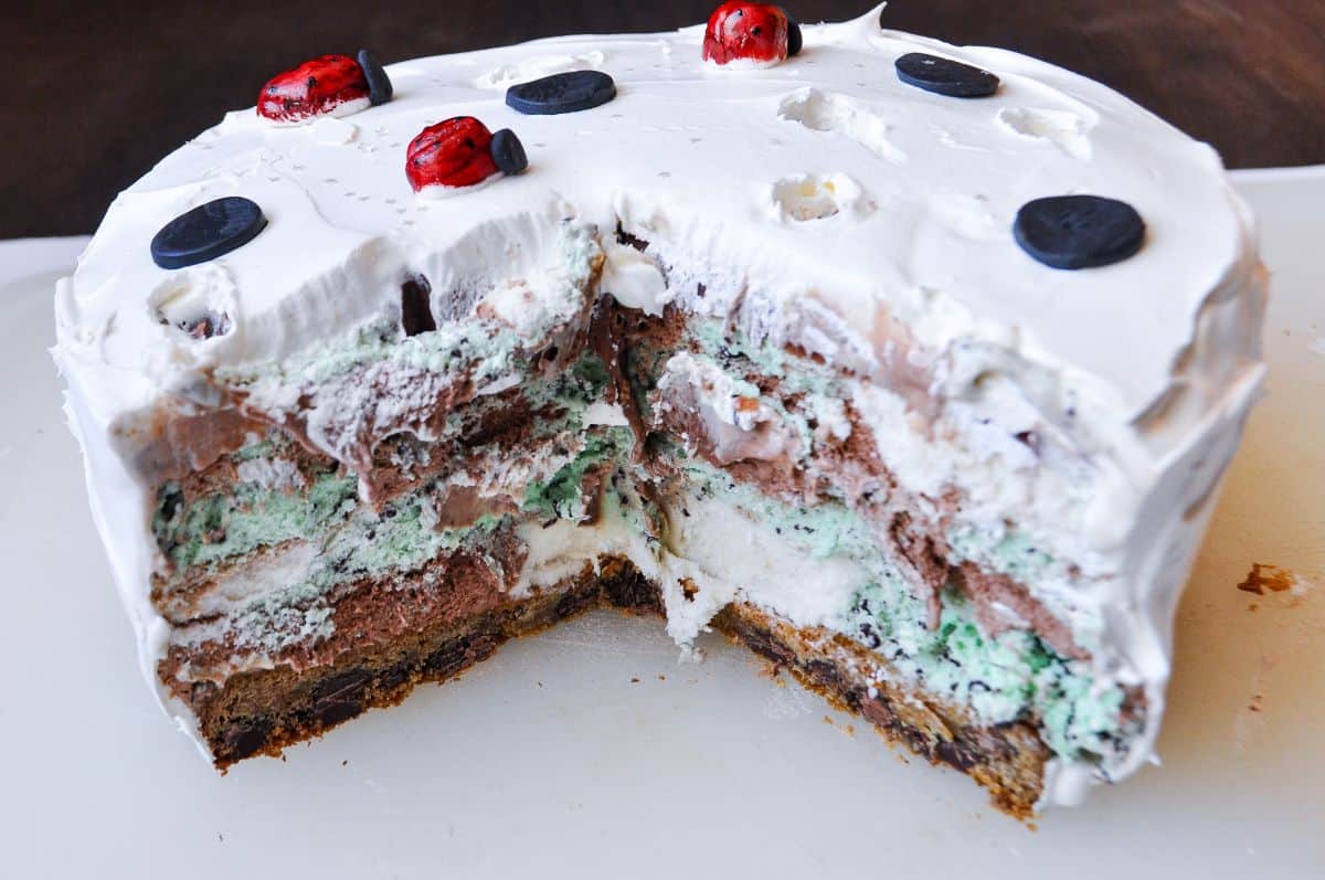 an ice cream cake with a section missing to show the inside layers