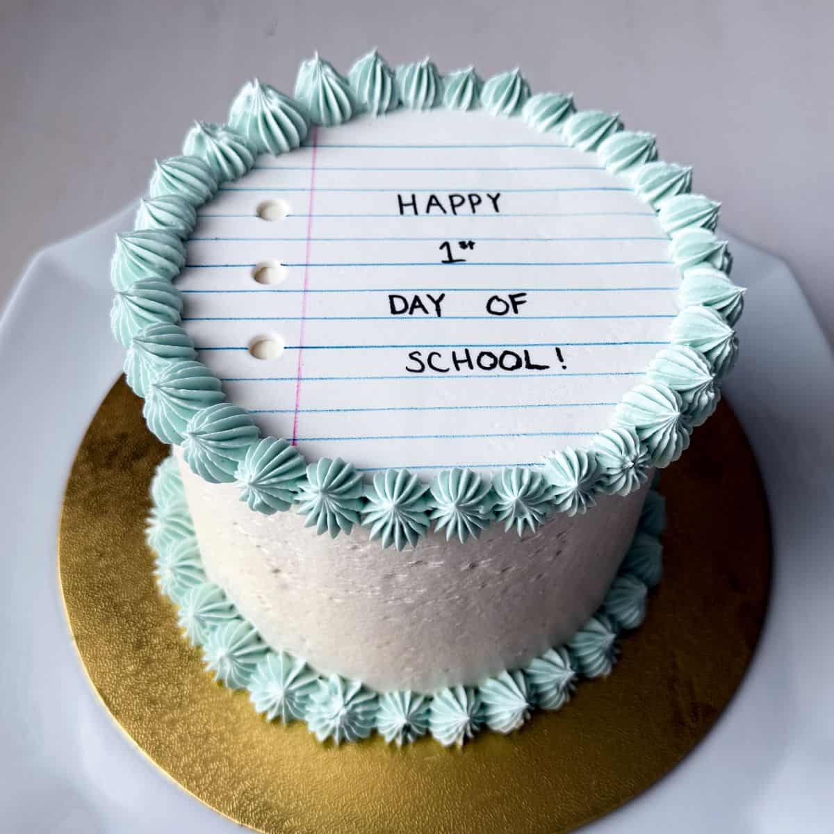 a First Day of School Cake that has a white fondant that looks like notebook paper on top