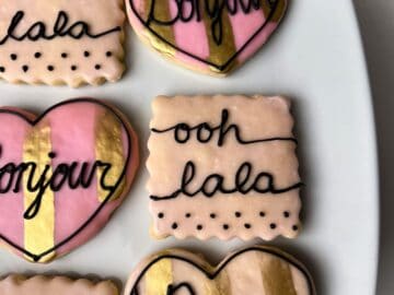 a pink cookie with black royal icing to say "ooh lala"