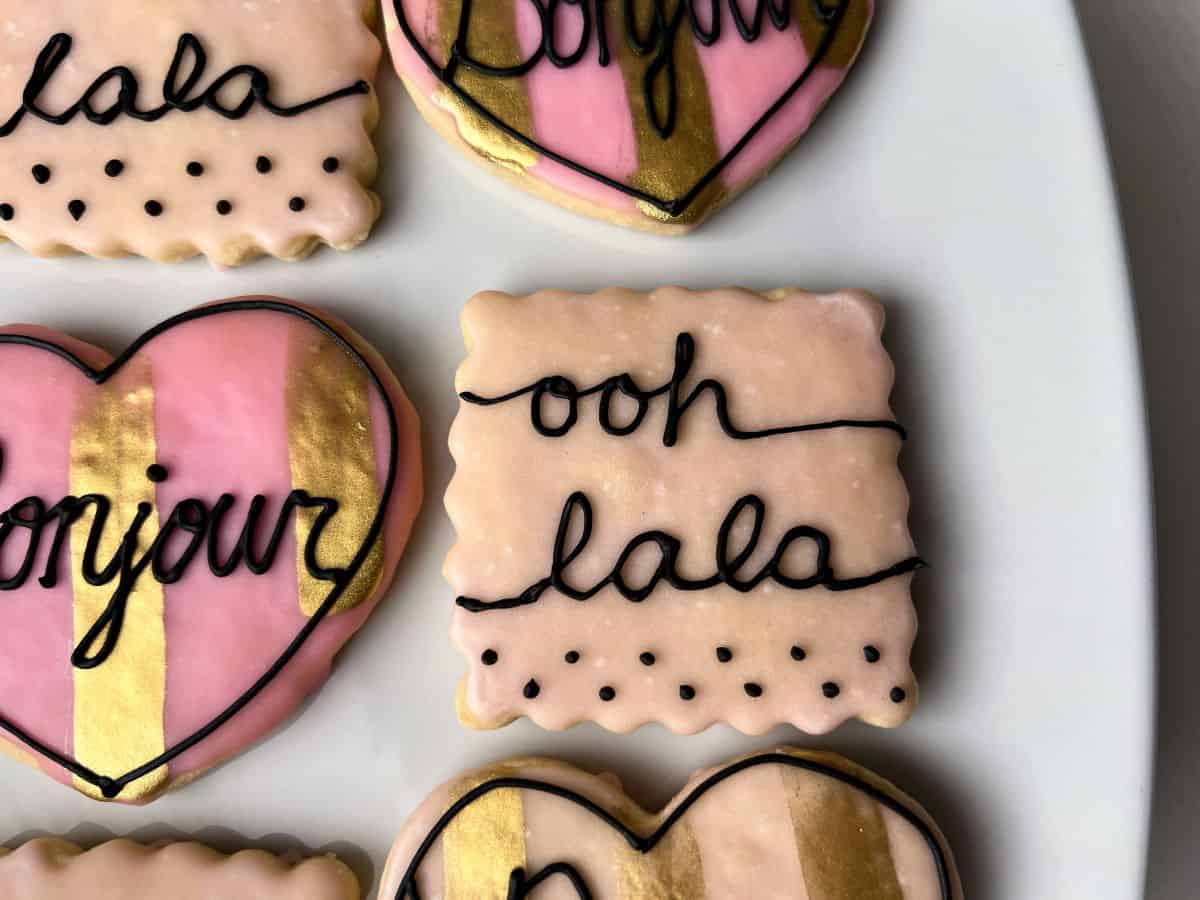 a pink cookie with black royal icing to say "ooh lala"